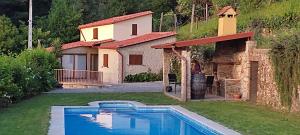 a house with a swimming pool in front of a house at Casa do Ribeiro in Sever do Vouga