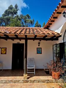 a house with a porch and a chair on a patio at La Casona Cucaita. Sede Campestre in Cucaita