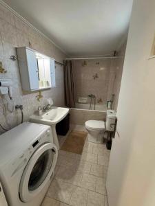 a bathroom with a washing machine and a toilet at Sunset Sea Apartment in Alexandroupoli