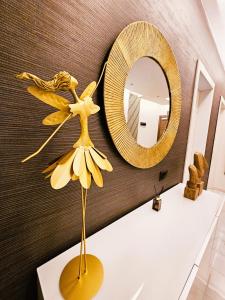 a fake flower on a table in front of a mirror at Delmar Coastal Retreat in St. Paul's Bay +39 photos