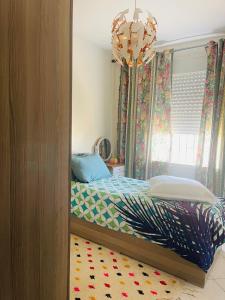 a bedroom with a bed and a chandelier at Jannat tamaris in Tamaris