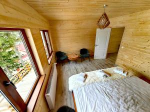 a bedroom with a bed in a wooden room at Cabane A-frame CeziAde Tihuta in Piatra Fantanele