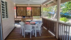 a screened in porch with a table and chairs at Fare Tua - Meko et Kito in Fakarava