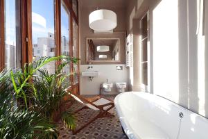a bathroom with a bath tub and two toilets at My Space Barcelona Rambla Catalunya Center in Barcelona