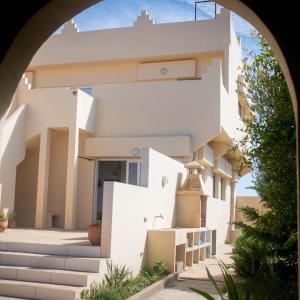 a white house with an archway in front of it at Darnejma Guesthouse Oualidia in Oualidia