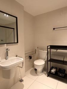 a bathroom with a toilet and a sink and a mirror at Flat Premiun Vila Madalena in São Paulo