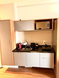 a kitchen with a sink and a microwave at Flat Premiun Vila Madalena in São Paulo