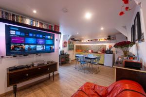a living room with a large flat screen tv at Loveroom, Les années 80 chez nounours in Templemars