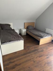 due letti in una stanza con pavimenti in legno di Wyłączony a Krotoszyce
