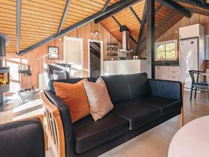 sala de estar con sofá negro en la cocina en Bright Cottage with Hot Tub - By Traum Ferienwohnungen, en Bøtø By