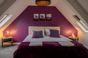 a purple bedroom with a bed with purple walls at 4br-sleeps8-privategarden-freeparking in Nottingham