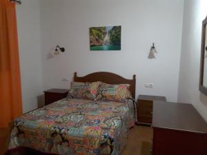 a small bedroom with a bed and a table at Residencial La Teja in Zahora