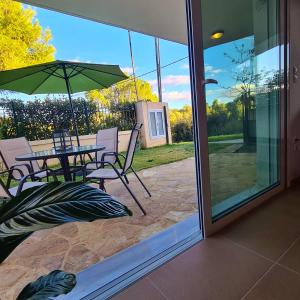 a patio with a table and chairs and an umbrella at Philoxenia Home Oropos / Just Moments from the Sea in Néa Palátia +23 photos