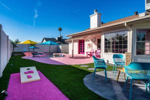 a backyard with chairs and a table on a lawn at Dollhouse Daydream! Barbie-Inspired Home in Peoria