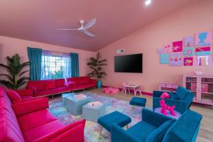 a living room with pink and blue furniture and a flat screen tv at Dollhouse Daydream! Barbie-Inspired Home in Peoria