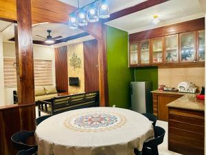 a kitchen with a table and a green wall at The Alusiman Home - 4 bedroom home in Iloilo City +59 photos