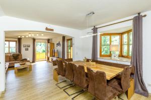 a dining room and living room with a table and chairs at Ferienhaus Thimlefi in Reit im Winkl