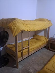 Litera en habitación con sábanas amarillas en Las Rosas, en Costa del Este