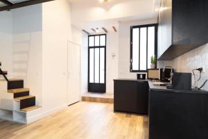 an office with a black counter and some windows at Studio 5 mn from Arc de triomphe - Champs-Élysées in Paris +6 photos