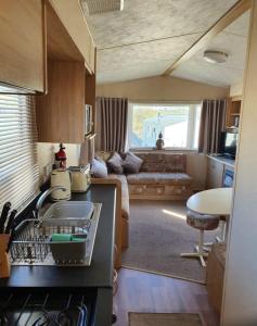 una cocina y sala de estar de una caravana en Pet Friendly 3 Bed Static Caravan in Clarach Bay Spacious and Cozy Stay, en Aberystwyth