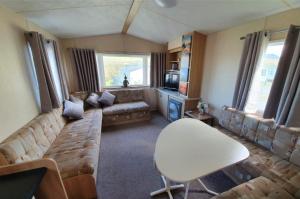 Una sala de estar con un sofá y un televisor. en Pet Friendly 3 Bed Static Caravan in Clarach Bay Spacious and Cozy Stay, en Aberystwyth 16 fotos más