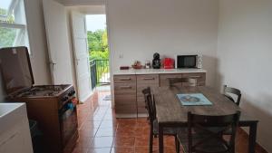 a kitchen with a table and a kitchen with a stove at Appartement F4 Kone centre Tel 7O 55 O8 in Koné