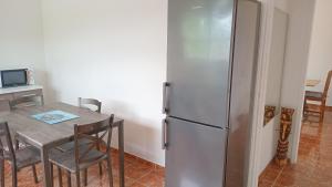 a kitchen with a refrigerator and a table with chairs at Appartement F4 Kone centre Tel 7O 55 O8 in Koné
