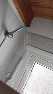 eine Dusche mit einem an der Decke hängenden Wasserschlauch in der Unterkunft Casita San Martín in San Martín de los Andes