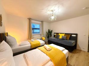a bedroom with two beds and a couch at YAY - 65m2 Apartment am Bahnhof - Smart TV - Internet - Kaffee - Waschmaschine - Trockner in Mühldorf