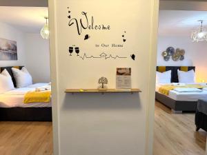 a room with two beds and a welcome to our home sticker at YAY - 65m2 Apartment am Bahnhof - Smart TV - Internet - Kaffee - Waschmaschine - Trockner in Mühldorf +27 photos