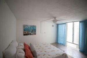 a bedroom with a bed and a ceiling fan at Beach & Country Beachfront Studio in Hauula