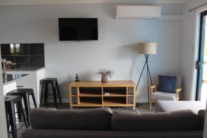 a living room with a couch and a tv on a wall at Country Style Accommodation Unit 2 in Ouyen