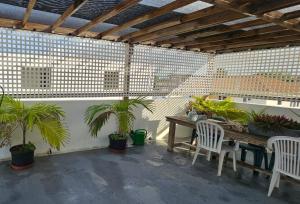 a patio with a wooden table and chairs and plants at Moon Moods Rooftop Apartment Curacao in Grote Berg