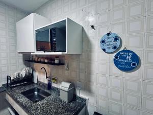 a kitchen with a sink and a microwave at Meu Loft Itauna 1 - Localização Privilegiada in Saquarema +17 photos