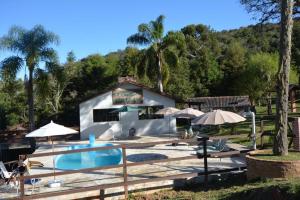 a resort with a swimming pool and umbrellas at CHACARA SERENA in Bocaiúva do Sul