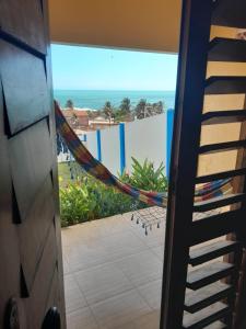 a hammock on a balcony with a view of the beach at Chalés Luz do Luar in Aracati