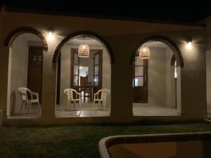 una casa con porche con sillas y luces en Casa Serena Mar, en Balneario El Condor