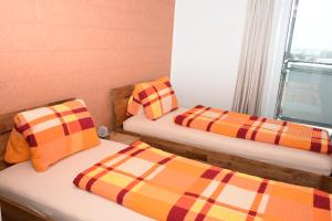 2 Betten in einem Zimmer mit karierten Kissen in der Unterkunft Towerhotel in Waldkirch