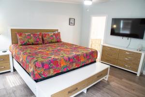 a bedroom with a bed and a flat screen tv at R3 Orange at Inlet Beach with Pool, EV Connector and RV Parking in Inlet Beach