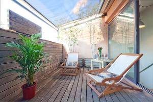 un patio con 2 sillas y una mesa en una terraza en My Space Barcelona Penthouse Terrace, en Barcelona