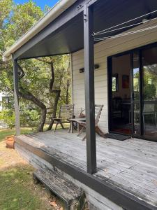 a porch of a house with a table and chairs at Whangapoua Paradise in Whangapoua