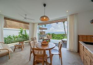 een keuken en woonkamer met een tafel en stoelen bij Villa Utopia in Nusa Lembongan