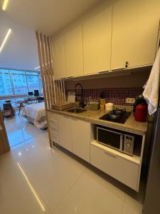 a kitchen with a sink and a microwave at Studio luxo em Santos vista ao mar in Santos