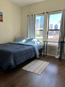 a bedroom with a bed and a large window at ELEGANT RESORT-SoCal-Lux on 3rd in Los Angeles