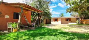 a house with a hammock outside of it at Pequizeiro Eco Pousada in Cavalcante