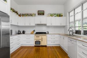Una cocina con gabinetes blancos y un horno de estufa. en Luxury Farm Homestead & Animal Sanctuary, Hot Tub, en The Pocket