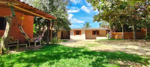 a house with a hammock in front of a yard at Pequizeiro Eco Pousada in Cavalcante