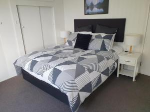 Un dormitorio con una cama con un edredón blanco y negro. en Charmae Guest House, en Whanganui 19 fotos más
