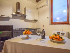 a table with a bowl of fruit and a bottle of wine at Apartment with Jacuzzi near Etna in Gaggi