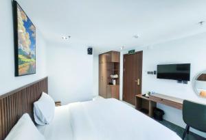 a bedroom with a bed and a desk with a television at Chill House in Quy Nhon